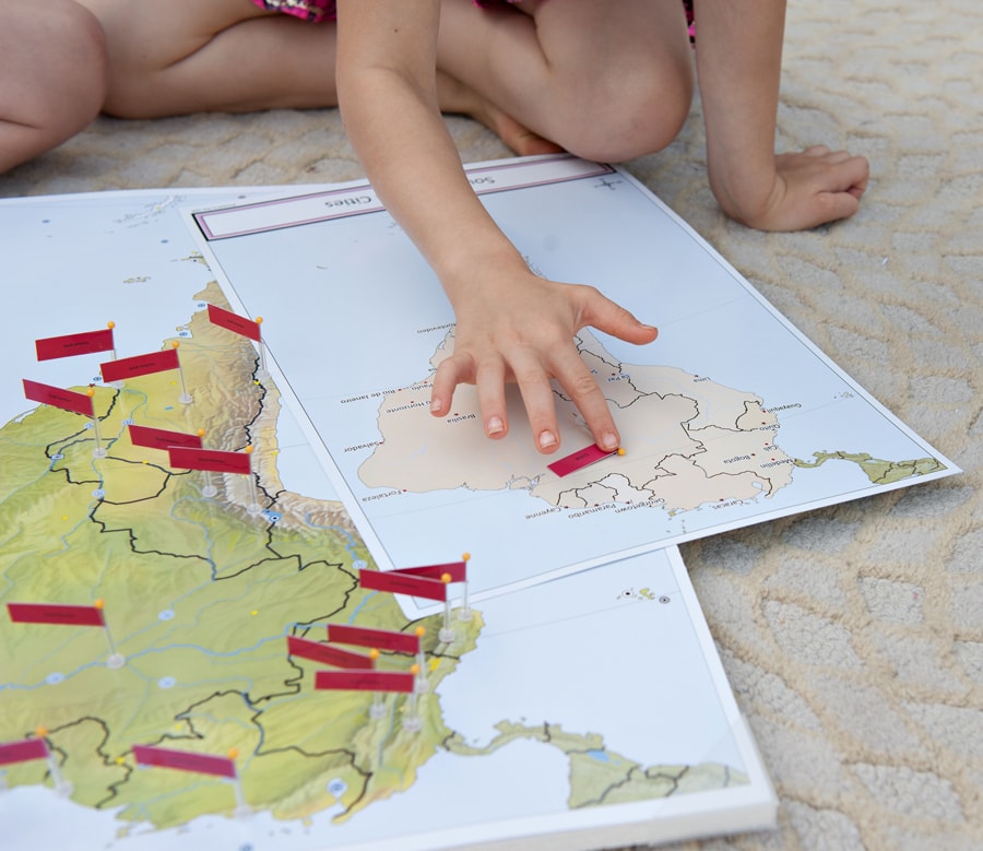 Children exploring South America pin maps on the floor — the original Pin It Maps product